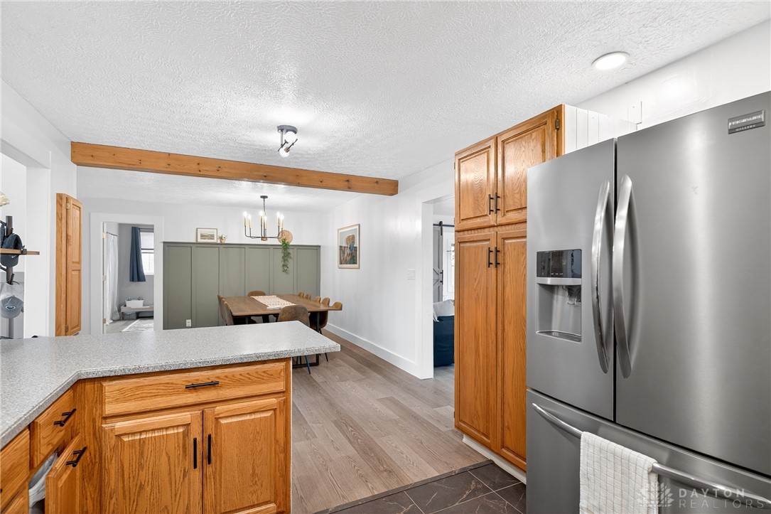 7888 Darke-Preble County Line Road Arcanum, OH 45304 - Photo 12 of 51 This spacious kitchen and dining area features exposed beams and modern appliances.