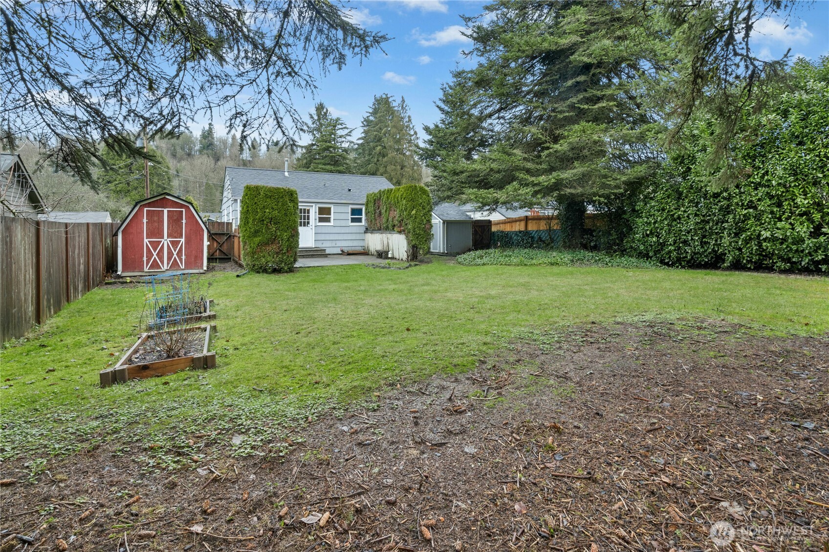 3125 Southeast 6th Street Renton, WA 98058 - Photo 25 of 27 a view of a backyard with large trees and a small barn