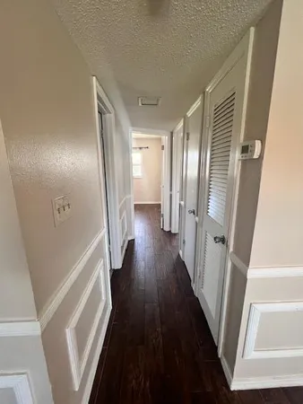 a view of a hallway with wooden floor and staircase