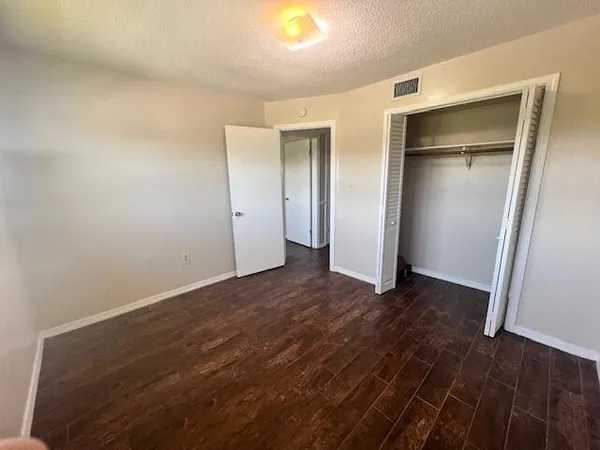 a view of an empty room with closet and a fireplace