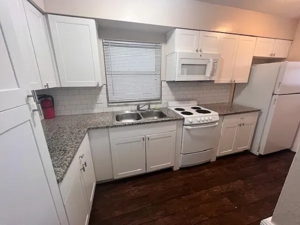 a kitchen with white cabinets sink and white appliances