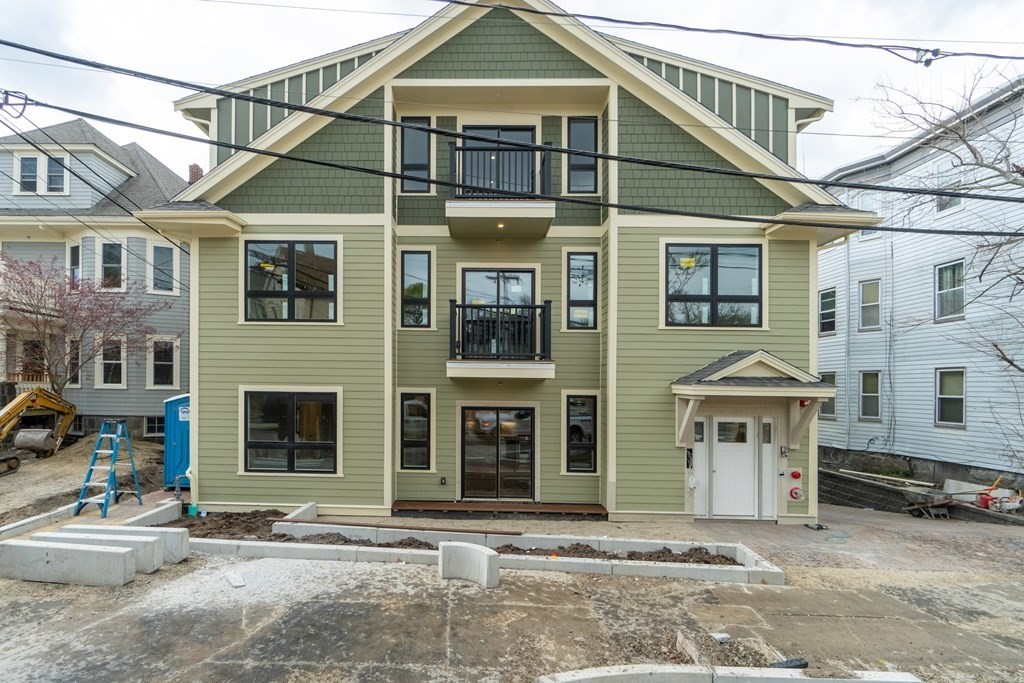 874 South Street, Unit 5 Boston, MA 02131 - Photo 16 of 19 a front view of a house with a yard and garage