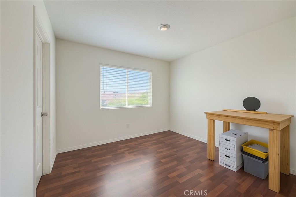 25768 Perlman Place, Unit A Stevenson Ranch, CA 91381 - Photo 11 of 20 a view of an empty room with wooden floor and a window