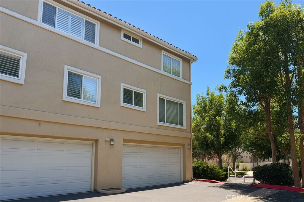 25768 Perlman Place, Unit A Stevenson Ranch, CA 91381 - Photo 16 of 20 a front view of a house with a garage