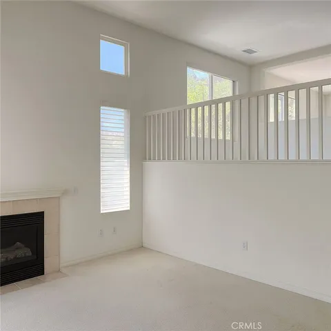 a view of an empty room with a window and fireplace