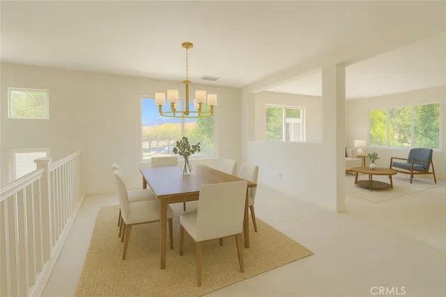a view of a dining room with furniture a chandelier and a large window