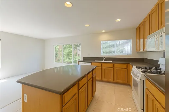 a kitchen that has a sink a stove a microwave a counter top space and cabinets