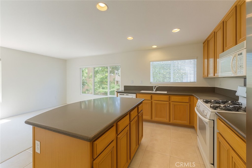 25768 Perlman Place, Unit A Stevenson Ranch, CA 91381 - Photo 10 of 20 a kitchen that has a sink a stove a microwave a counter top space and cabinets