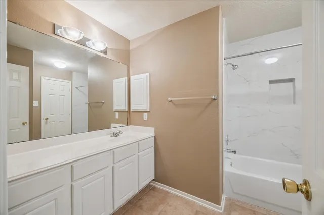 a spacious bathroom with a tub sink and mirror