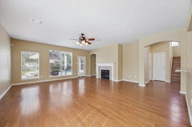 a view of an empty room with a window and wooden floor
