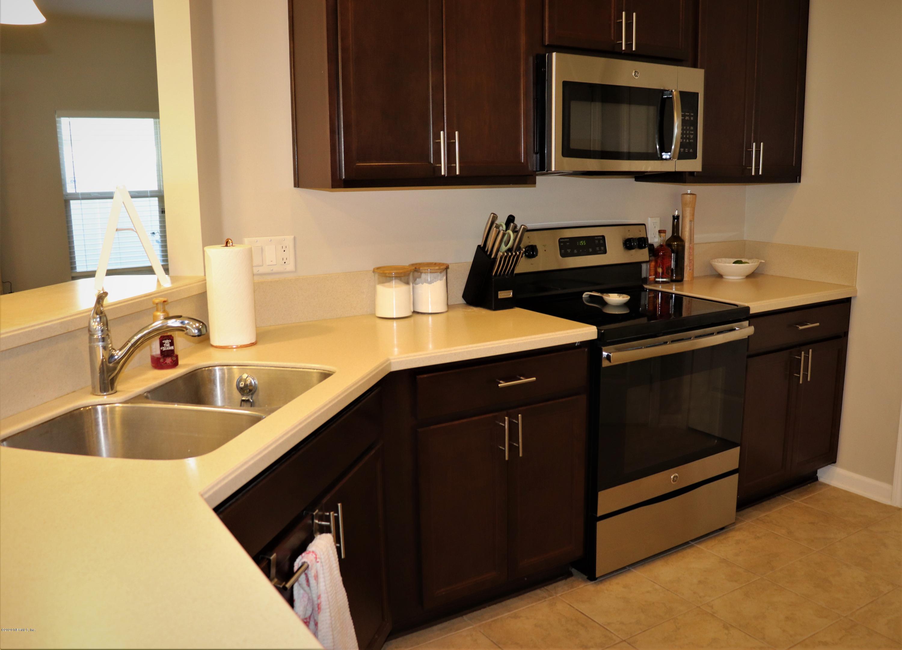 12294 Rouen Cove Drive Jacksonville, FL 32226 - Photo 18 of 41 a kitchen with a sink and a stove top oven with wooden floor