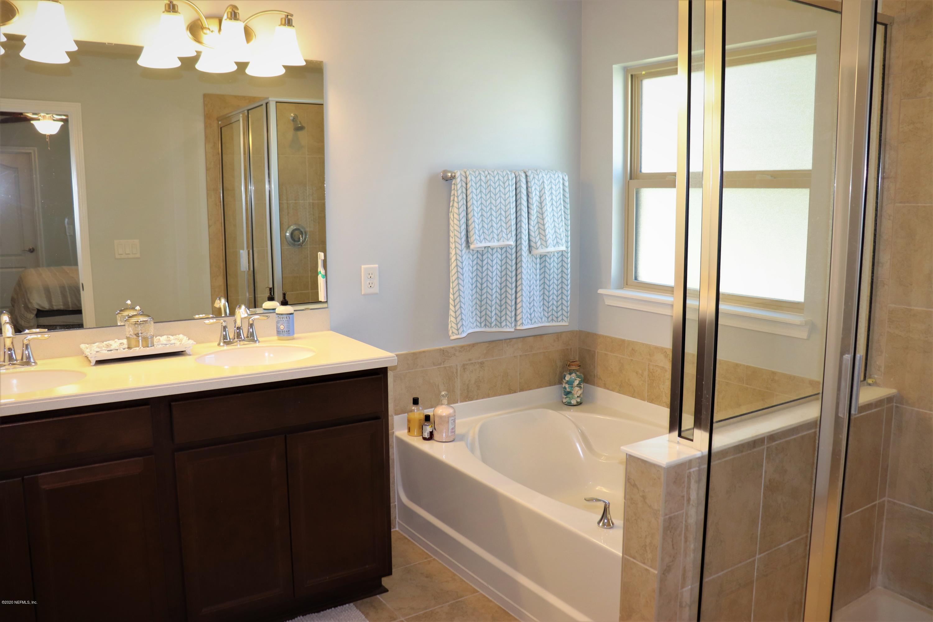 12294 Rouen Cove Drive Jacksonville, FL 32226 - Photo 28 of 41 a bathroom with a tub sink and mirror