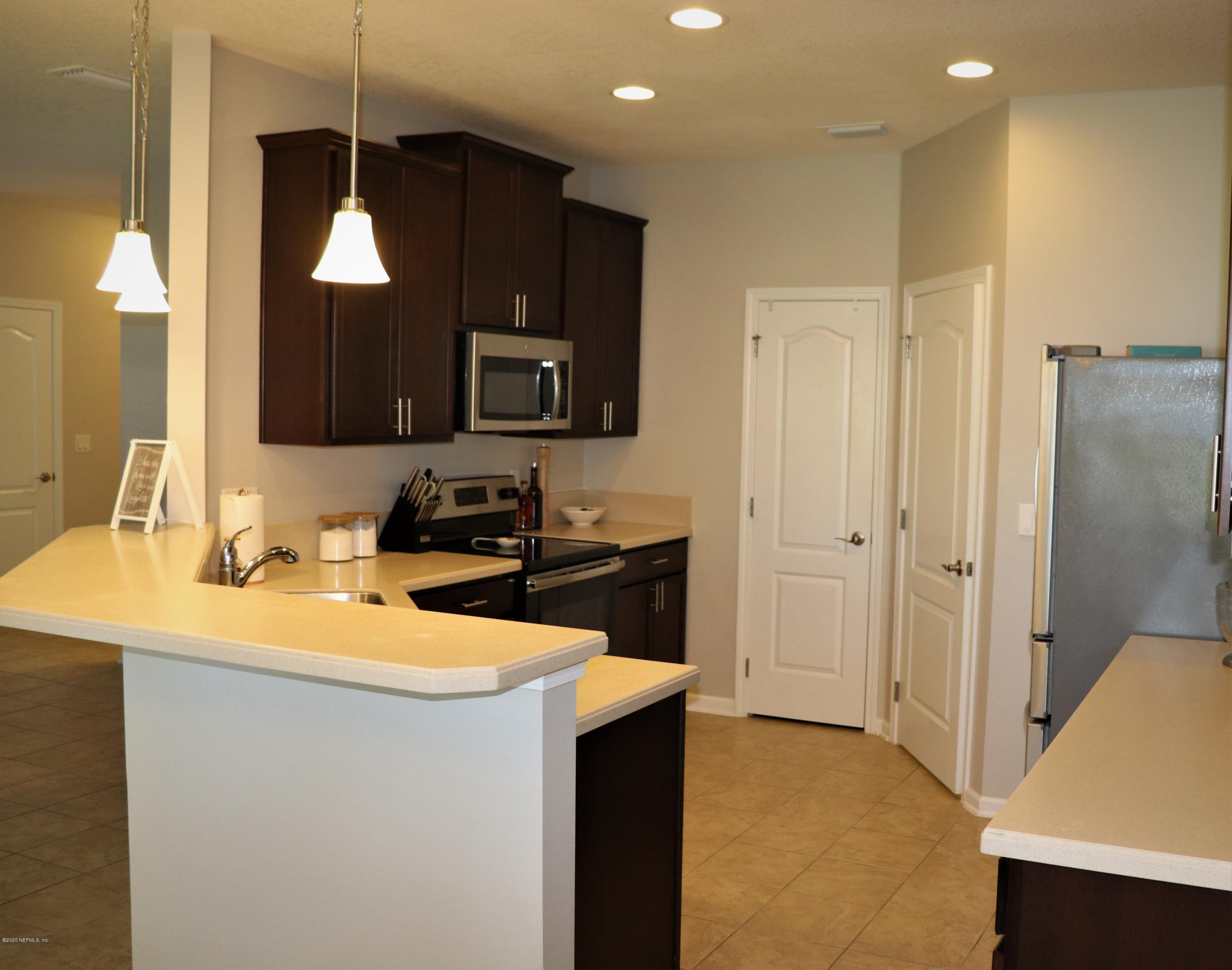 12294 Rouen Cove Drive Jacksonville, FL 32226 - Photo 4 of 41 a kitchen with a sink a counter top space cabinets and stainless steel appliances