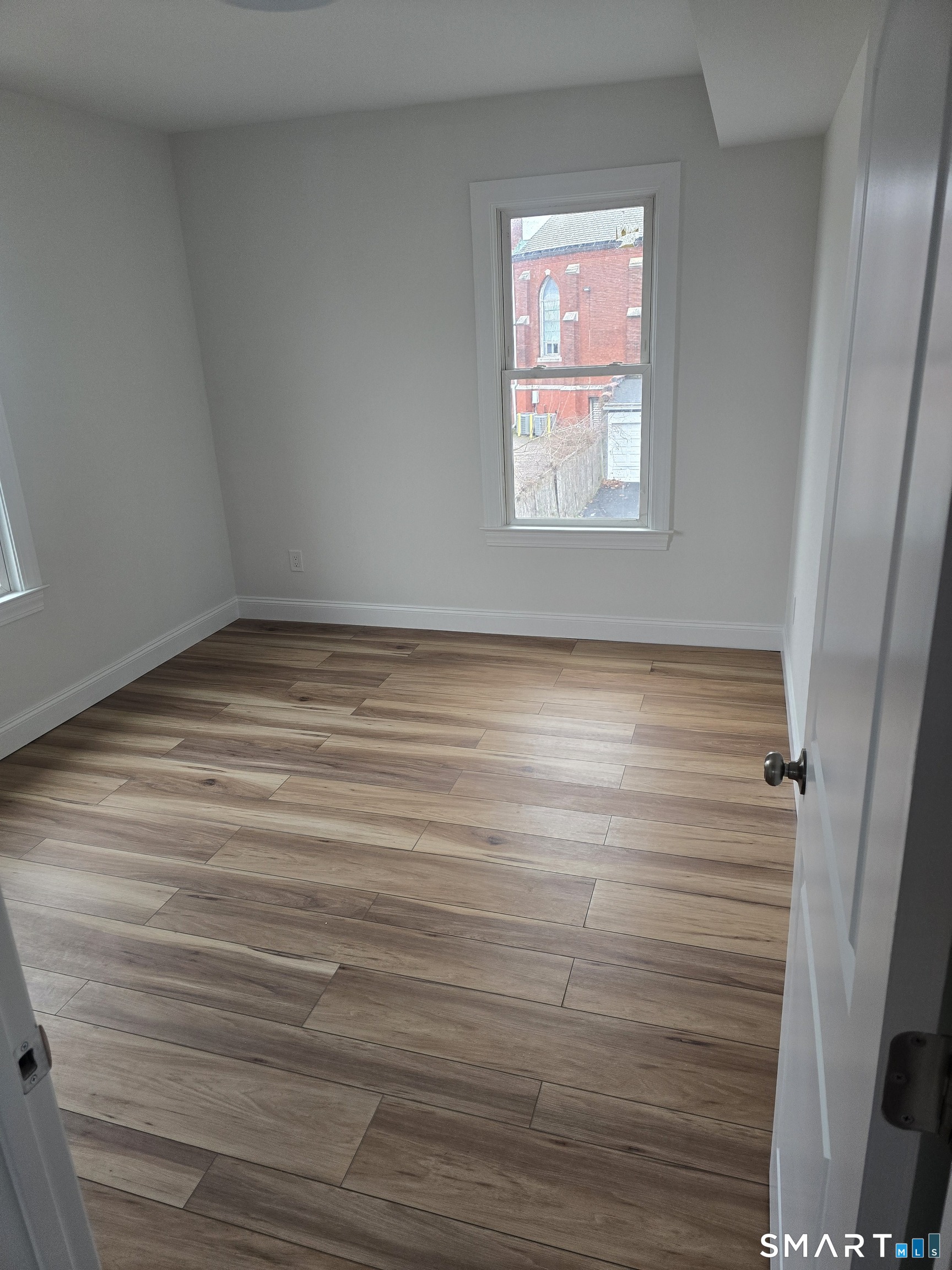 530 Jane Street, Unit 2 Bridgeport, CT 06608 - Photo 8 of 9 a view of empty room with window and wooden floor
