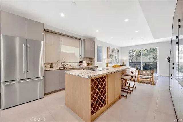 a kitchen with a refrigerator a sink dishwasher with a dining table and chairs