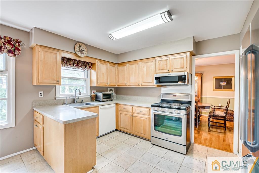 72 Monroe Avenue Edison, NJ 08820 - Photo 11 of 35 a kitchen with a stove sink and microwave