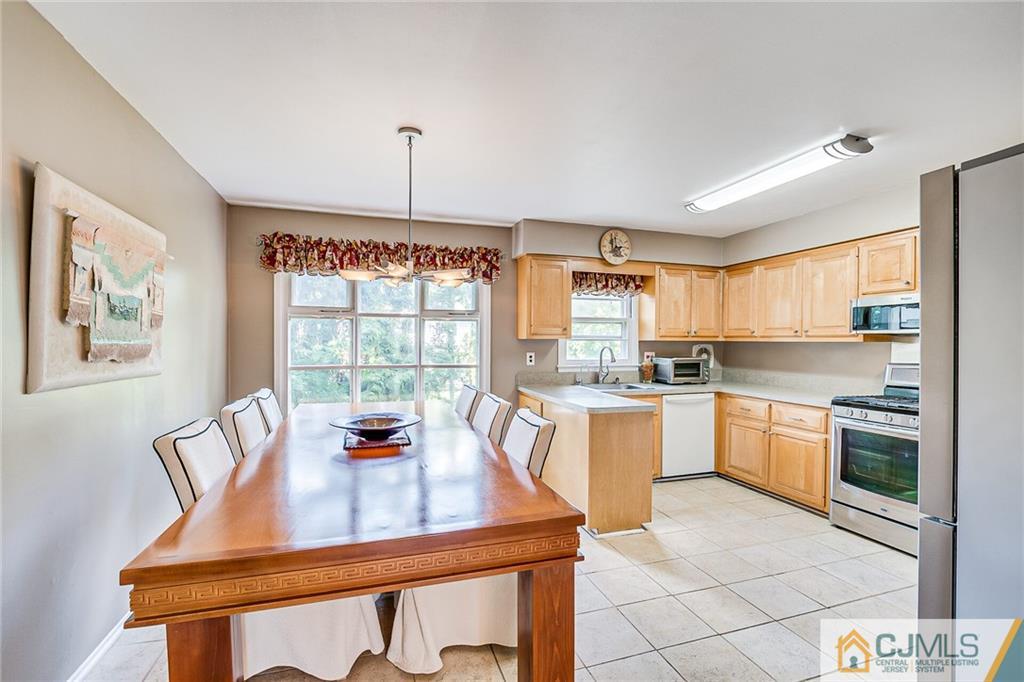 72 Monroe Avenue Edison, NJ 08820 - Photo 13 of 35 a kitchen with a stove a sink dishwasher a dining table and chairs with wooden floor