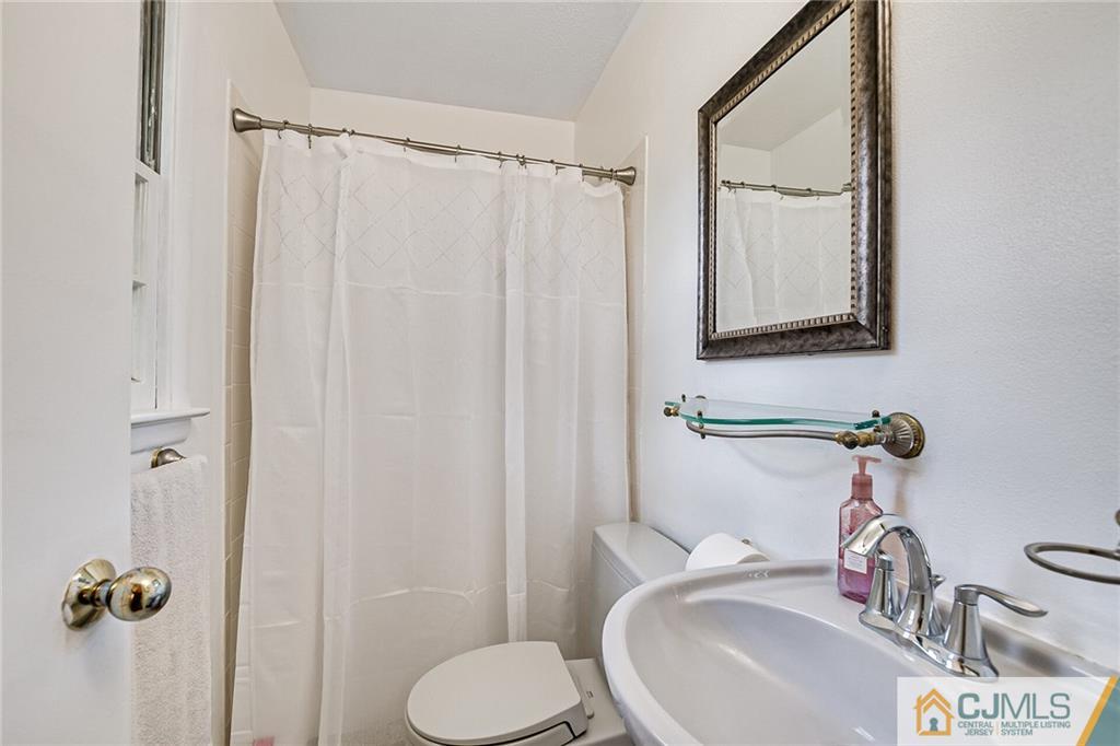 72 Monroe Avenue Edison, NJ 08820 - Photo 21 of 35 a bathroom with a sink a toilet and a mirror