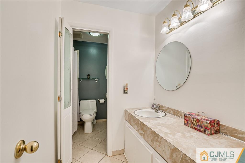 72 Monroe Avenue Edison, NJ 08820 - Photo 25 of 35 a bathroom with a granite countertop sink and a mirror