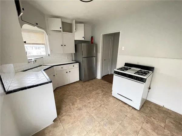 a kitchen with granite countertop a refrigerator a stove a sink and dishwasher