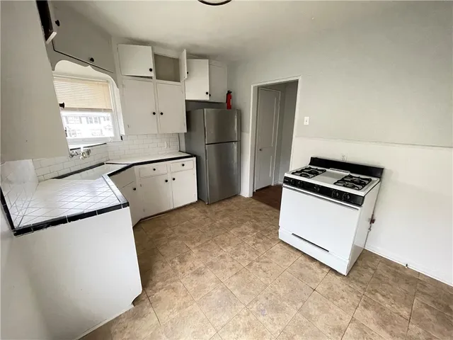 a kitchen with granite countertop a refrigerator a stove a sink and dishwasher
