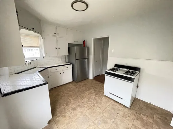 a kitchen with white cabinets and stainless steel appliances