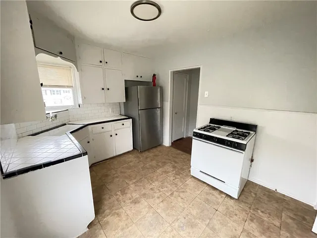 a kitchen with white cabinets and stainless steel appliances