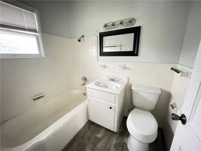 a bathroom with a toilet sink and mirror