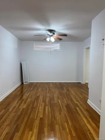 a view of a room with wooden floor and ceiling fan