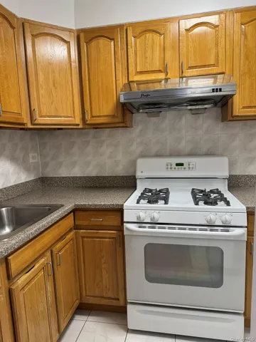 a kitchen with granite countertop cabinets stainless steel appliances and wooden floor