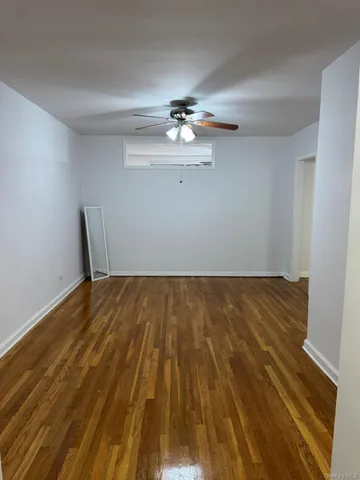a view of a room with wooden floor and a ceiling fan