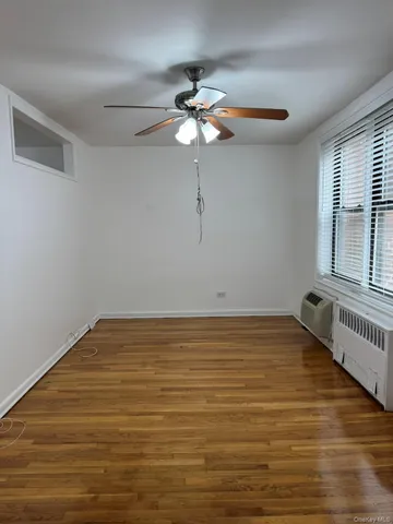 a view of a room with wooden floor and a ceiling fan