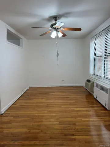a view of a room with wooden floor and a ceiling fan