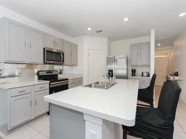 a large white kitchen with stainless steel appliances