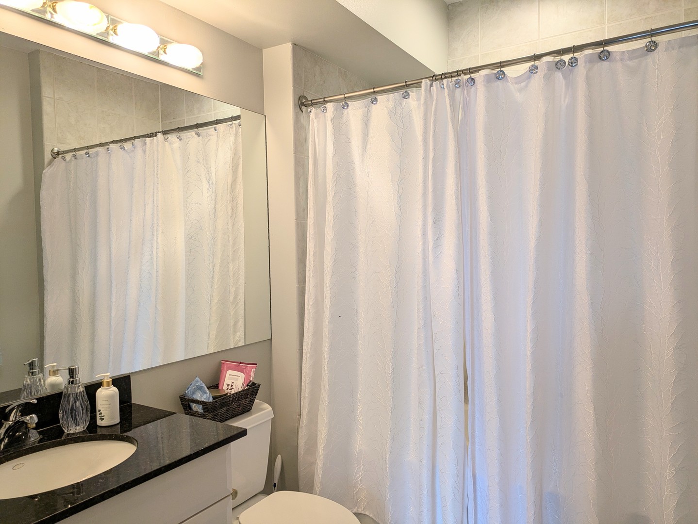 33 West Ontario Street, Unit 40D Chicago, IL 60654 - Photo 13 of 32 a bathroom with a granite countertop sink and a mirror