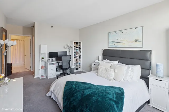 a bedroom with a bed and a flat tv screen on the dresser