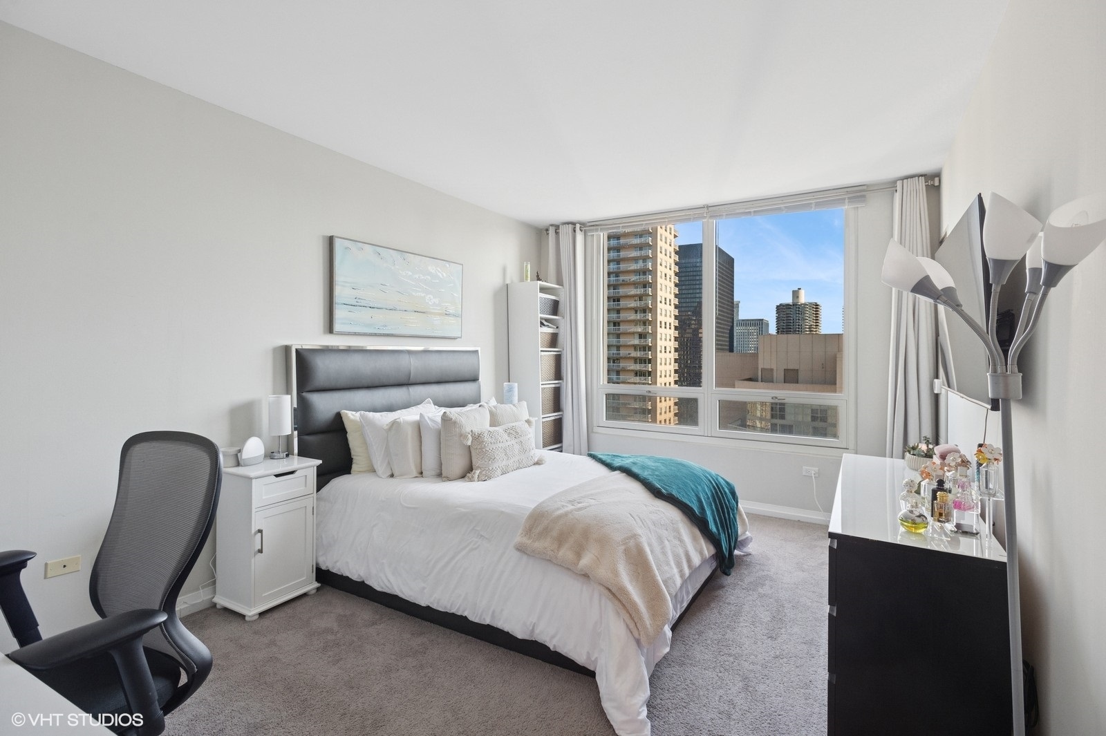 33 West Ontario Street, Unit 40D Chicago, IL 60654 - Photo 18 of 40 a bedroom with a bed a chair and large mirror next to a window