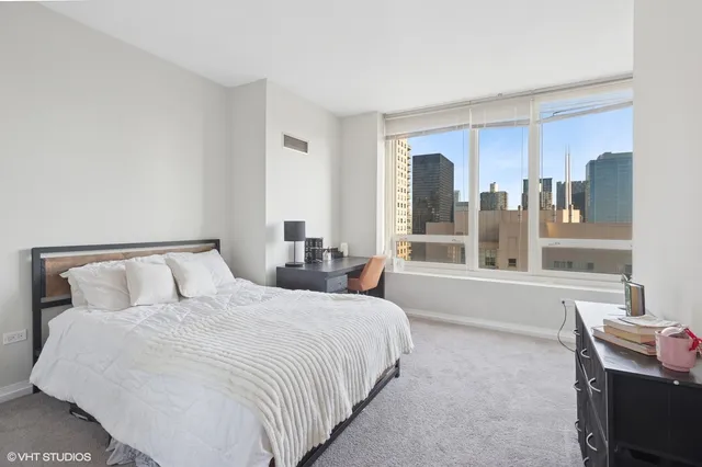 a large bed sitting in a room next to a window
