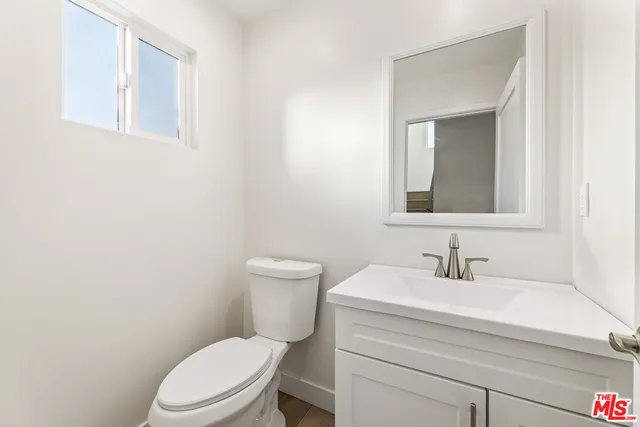 a bathroom with a toilet a sink and mirror
