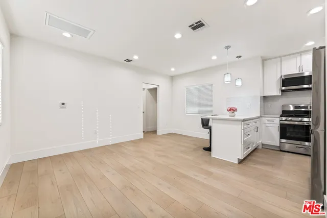 a kitchen with kitchen island a sink and a stove top oven