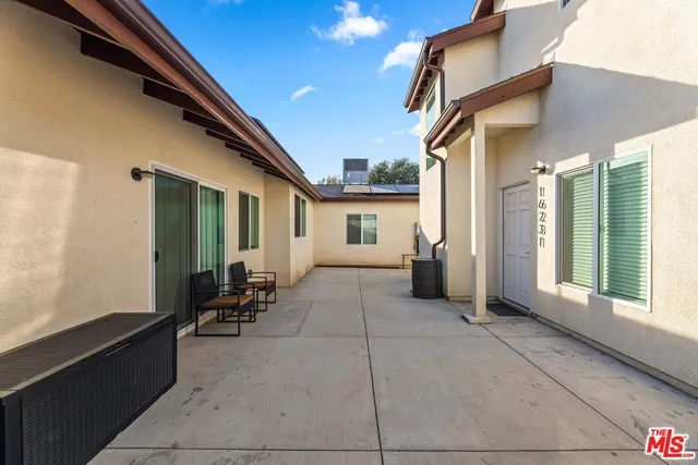 a view of a patio with table and chairs and floor to ceiling window