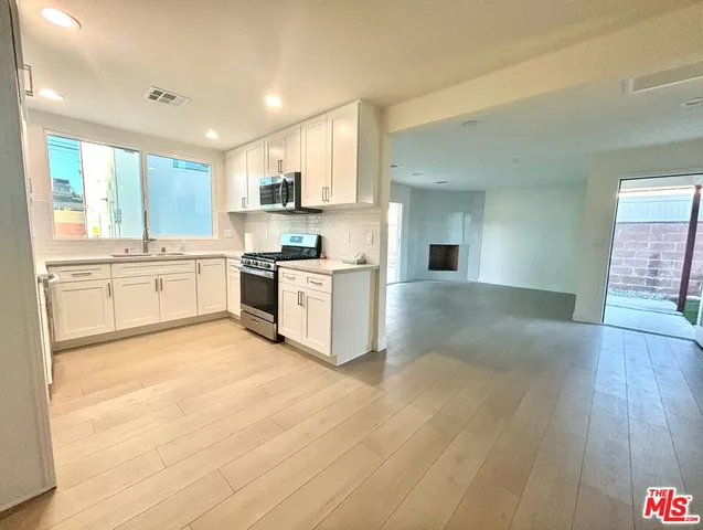 a large kitchen with cabinets and wooden floor