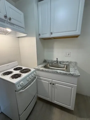 a kitchen with granite countertop cabinets sink and stove
