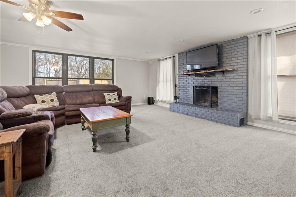 100 Sands Drive Azle, TX 76020 - Photo 11 of 31 a living room with furniture a fireplace and a flat screen tv