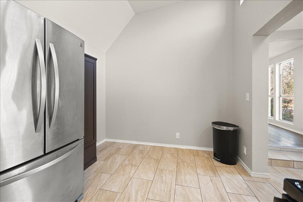 100 Sands Drive Azle, TX 76020 - Photo 15 of 31 a view of a refrigerator in kitchen and an empty room