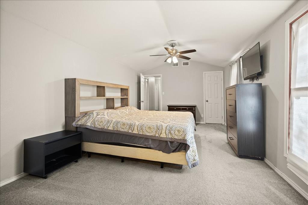 100 Sands Drive Azle, TX 76020 - Photo 24 of 31 a bedroom with a bed dresser and a chandelier