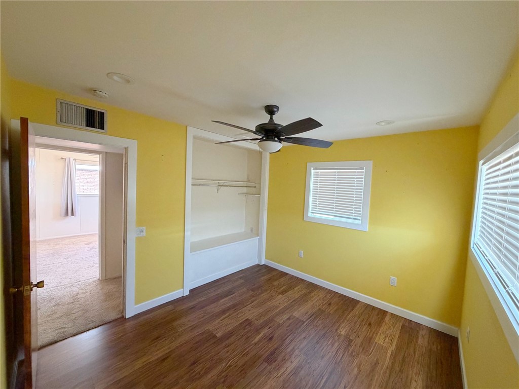 15691 Apache Loop Ehrenberg, AZ 85334 - Photo 16 of 24 Room featuring wood-finish flooring, a ceiling fan, and two windows with blinds
