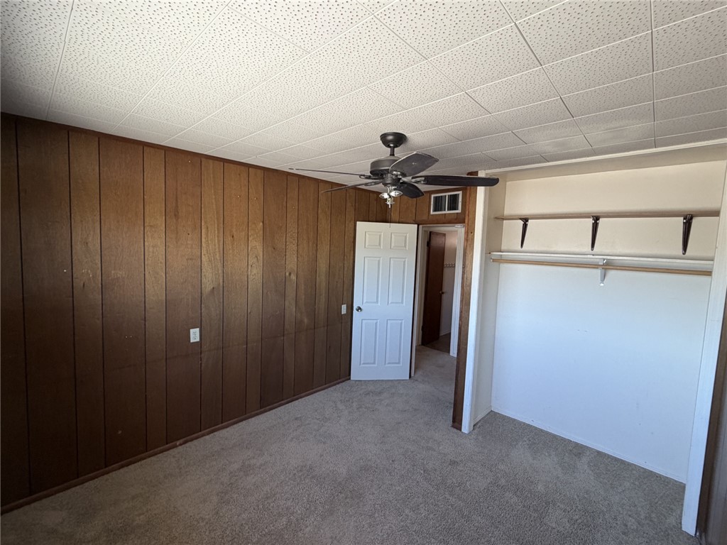 15691 Apache Loop Ehrenberg, AZ 85334 - Photo 17 of 24 Room featuring wood-paneled walls, neutral carpet flooring, and a drop ceiling with integrated lighting