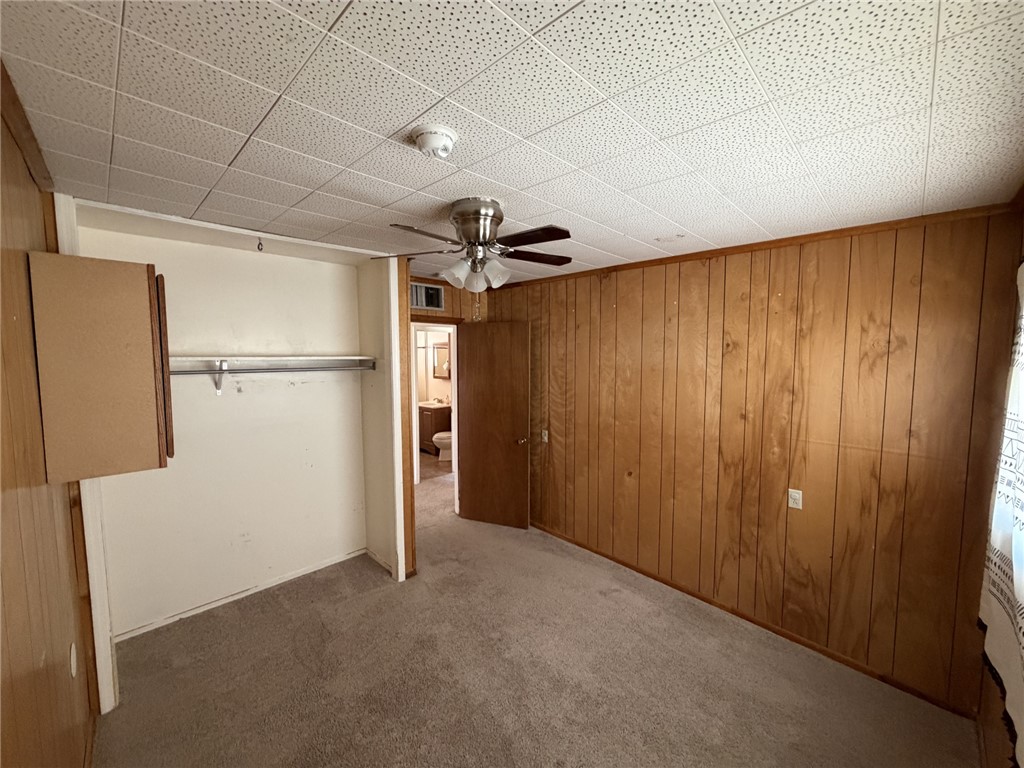 15691 Apache Loop Ehrenberg, AZ 85334 - Photo 21 of 24 Carpeted interior space featuring wood-paneled walls and a drop ceiling