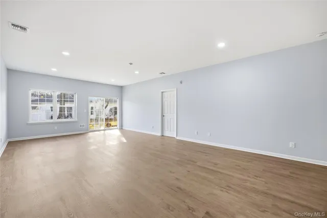 a view of a livingroom with wooden floor and a window